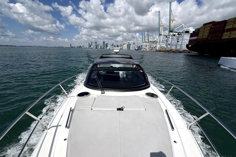 Slide: The Image of 2024 Schaefer 400 yacht cruising near city skyline and shipping port. - 7