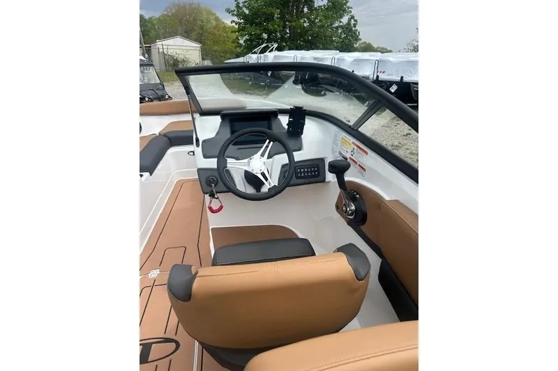 Slide: The Image of 2026 Tahoe 210 S boat interior with steering wheel and tan seating. - 10