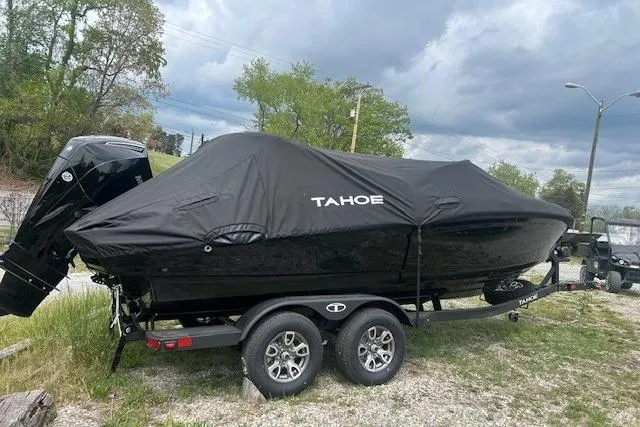 Slide: The Image of 2026 Tahoe 210 S boat covered on trailer, parked outdoors under cloudy sky. - 111
