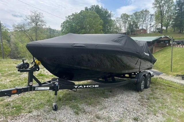 Slide: The Image of 2026 Tahoe 210 S boat covered on trailer, parked outdoors. - 4