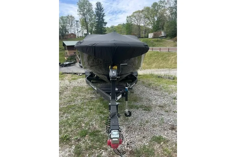 Slide: The Image of 2026 Tahoe 210 S boat covered and parked on a gravel surface. - 5