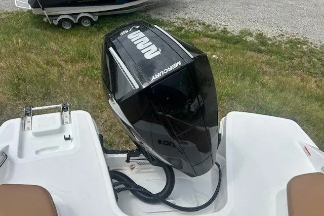 Slide: The Image of 2026 Tahoe 210 S boat with a Mercury outboard motor, parked on grass. - 8