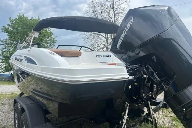 Slide: The Image of 2026 Tahoe 210 S boat with Mercury engine, parked outdoors. - 9