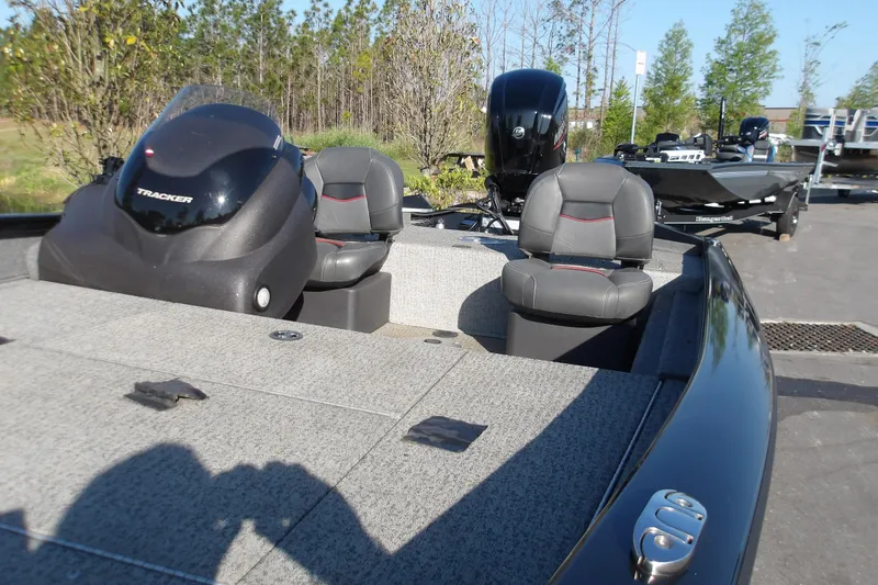 Slide: The Image of 2023 Tracker Pro Team 175 TXW fishing boat with dual seats and motor, parked outdoors. - 5