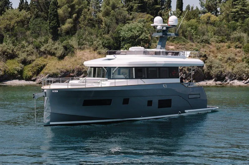 Slide: The Image of 2025 Sirena 58 yacht on serene water, surrounded by lush greenery. - 2