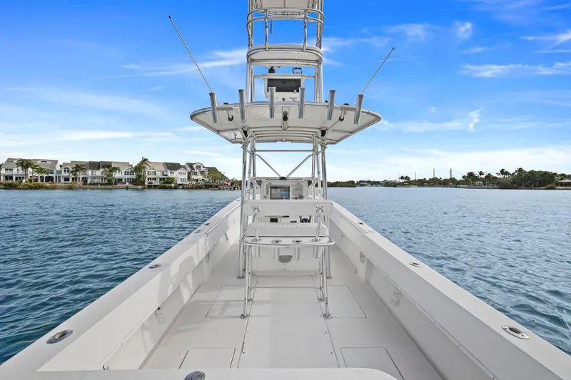 Slide: The Image of 2002 Contender 31 Open boat on calm water with coastal homes in the background. - 17