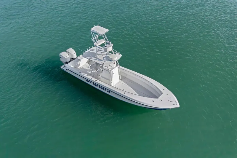 Slide: The Image of 2002 Contender 31 Open boat on clear turquoise water, aerial view. - 2