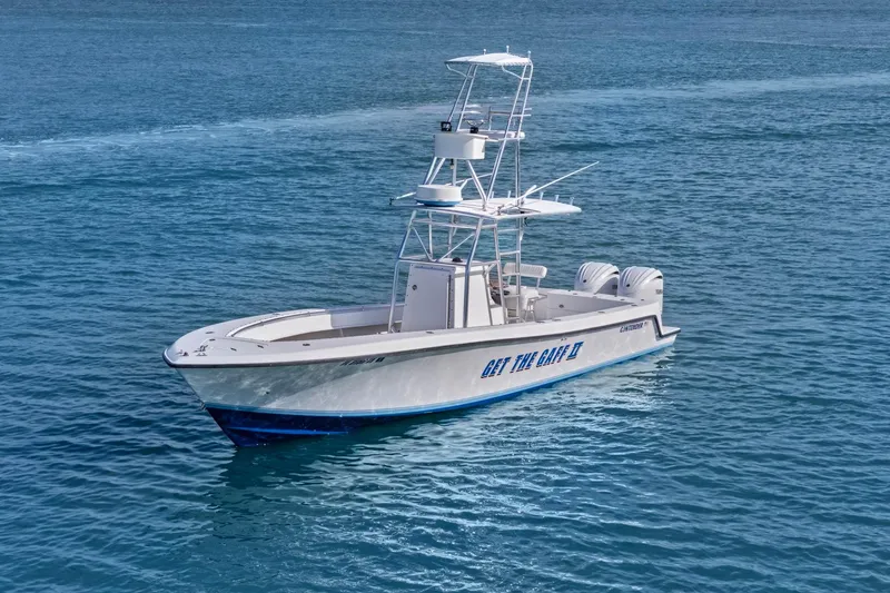 Slide: The Image of 2002 Contender 31 Open boat on calm blue water, featuring dual outboard engines. - 3