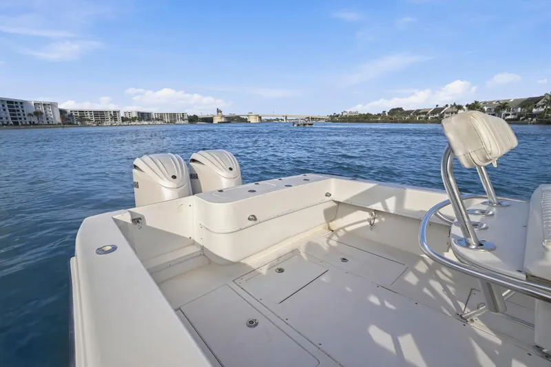 Slide: The Image of 2002 Contender 31 Open boat with dual Yamaha engines on a calm waterway. - 31