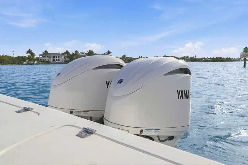 Slide: The Image of Twin Yamaha outboard engines on a 2002 Contender 31 Open boat, cruising in clear blue waters. - 34