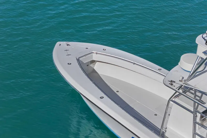 Slide: The Image of 2002 Contender 31 Open boat on clear blue water, showcasing sleek design and spacious deck. - 5