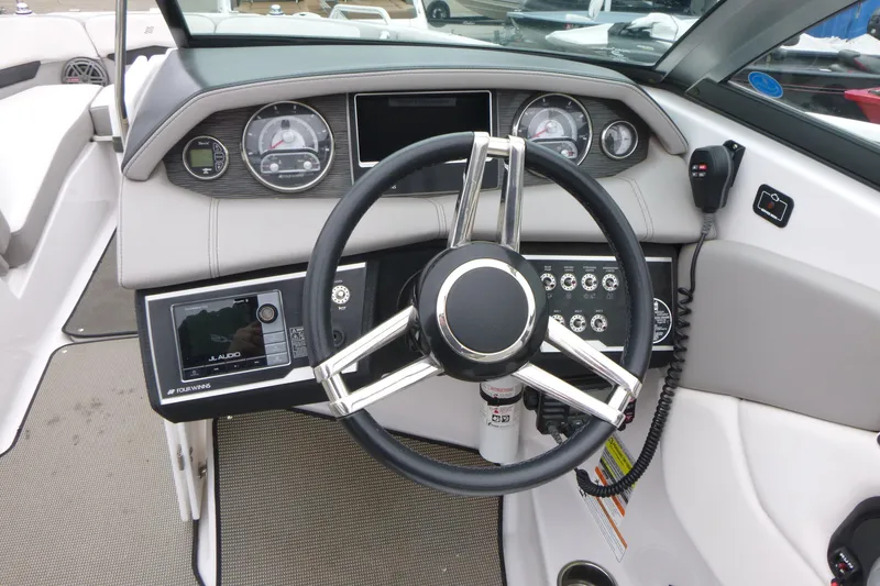 Slide: The Image of 2017 Four Winns H260 boat dashboard with steering wheel and control panel. - 8