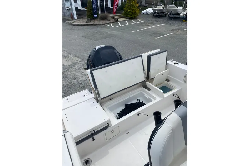 Slide: The Image of 2023 Robalo R230 Center Console boat with open storage compartments and seating. - 13