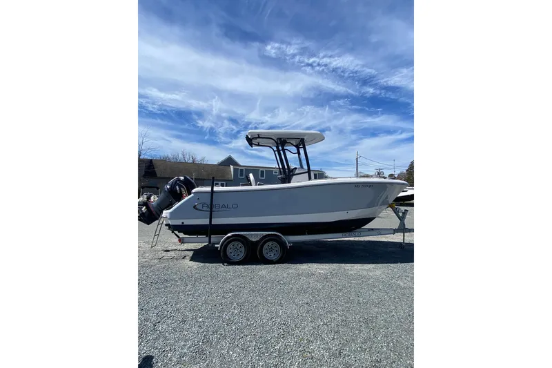 Slide: The Image of 2023 Robalo R230 Center Console boat on trailer under blue sky. - 2