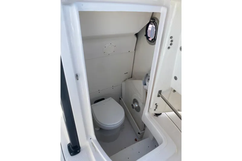 Slide: The Image of 2023 Robalo R230 Center Console boat interior with compact marine toilet. - 7