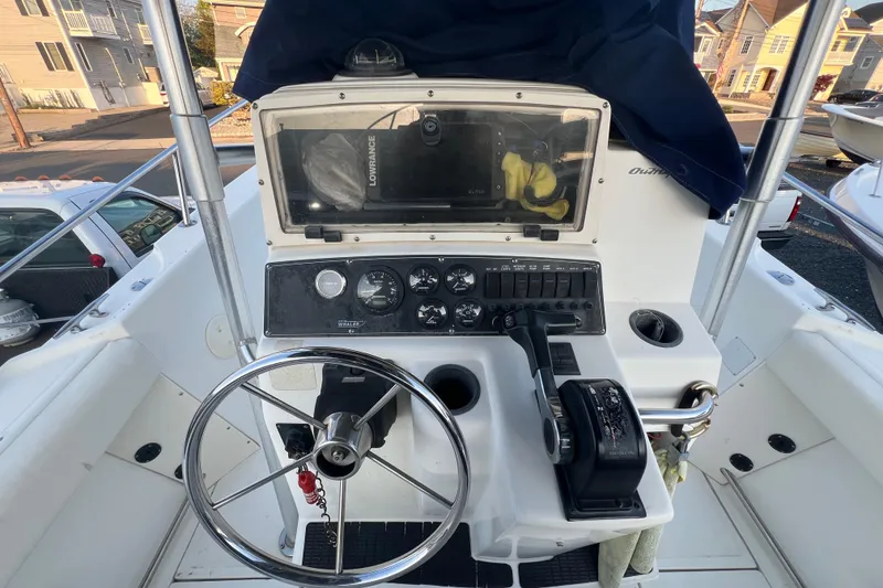Slide: The Image of 1998 Boston Whaler Outrage 23 boat console with steering wheel and navigation controls. - 11