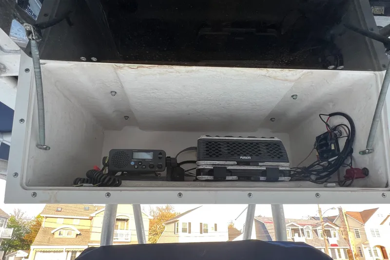 Slide: The Image of Electronics compartment on a 1998 Boston Whaler Outrage 23 boat, featuring communication and audio equipment. - 12