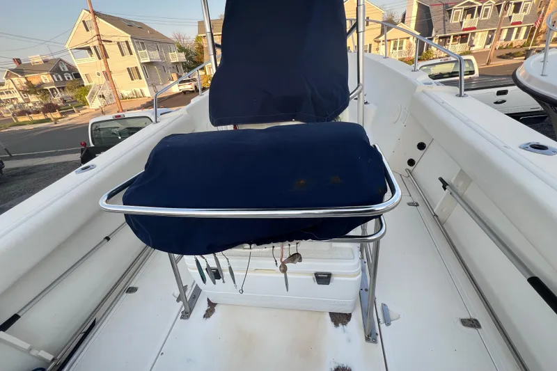 Slide: The Image of 1998 Boston Whaler Outrage 23 boat interior with blue seat covers and fishing gear. - 7