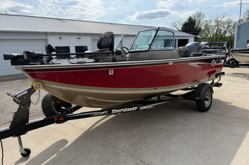 Slide: The Image of 2013 G3 Angler V185 SF boat on trailer, red and beige, parked outdoors. - 2