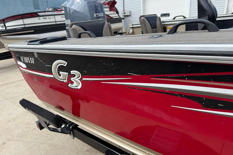 Slide: The Image of 2013 G3 Angler V185 SF boat with red and black detailing, parked on a trailer. - 39