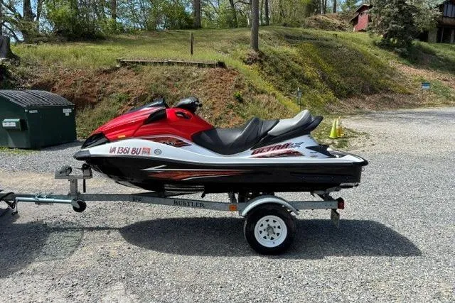 The Image of 2012 Kawasaki Jetski Ultra LX on trailer, parked outdoors on gravel. - 1