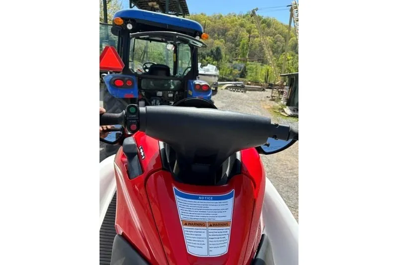 Slide: The Image of Red 2012 Kawasaki Jetski Ultra LX parked outdoors, with a tractor in the background. - 13