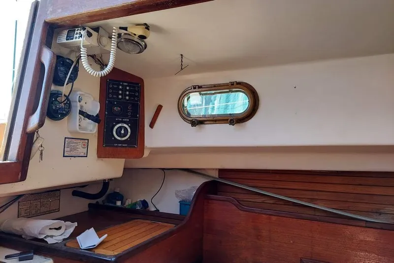 Slide: The Image of Interior of a 1989 Cape Dory 27 sailboat, featuring navigation equipment and a porthole. - 6