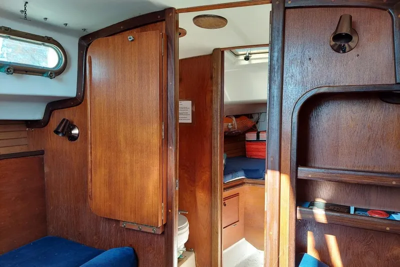Slide: The Image of Interior of a 1989 Cape Dory 27 sailboat with wooden cabinetry and cozy seating. - 7