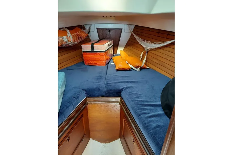 Slide: The Image of Cozy cabin interior of 1989 Cape Dory 27 sailboat with blue cushions and wooden accents. - 8