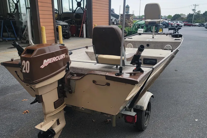 Slide: The Image of 2001 Nova NV JWMV1650SF boat with Mercury 20 outboard motor, parked outdoors. - 2