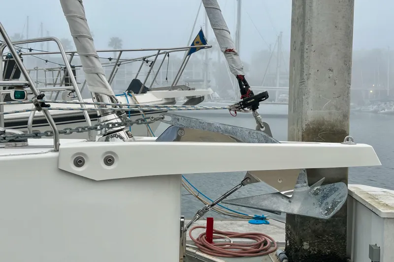 Slide: The Image of Bavaria C50 yacht anchored at a foggy marina, showcasing anchor and rigging. - 10