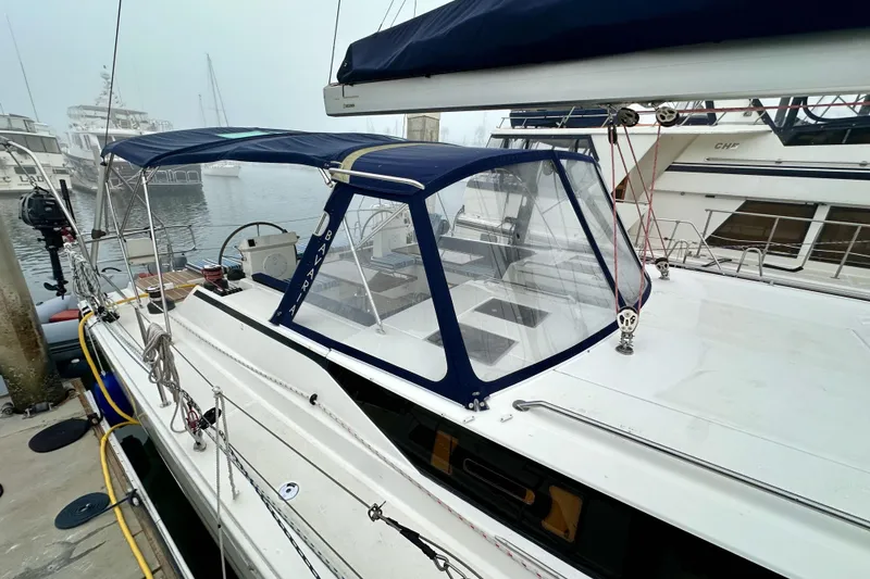 Slide: The Image of 2020 Bavaria C50 yacht docked, featuring a blue canopy and sleek design. - 16