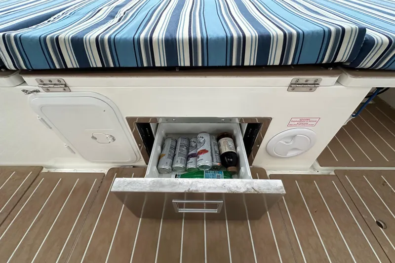 Slide: The Image of Bavaria C50 yacht with striped cushion and open drawer containing beverages, 2020 model. - 38