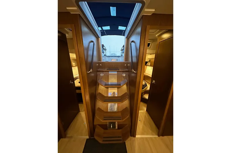 Slide: The Image of Interior view of 2020 Bavaria C50 yacht, featuring wooden stairs and cabin access. - 78