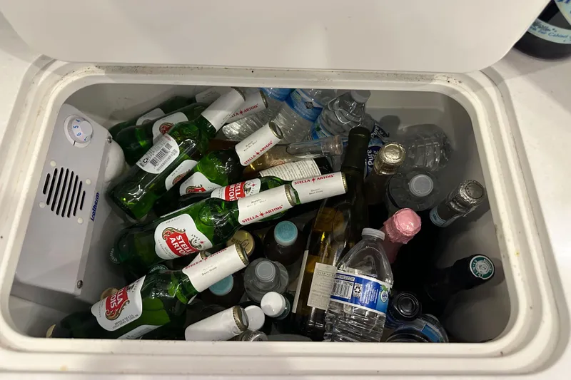 Slide: The Image of Cooler filled with assorted drinks, including beer and water bottles, on a Bavaria C50 yacht. - 86