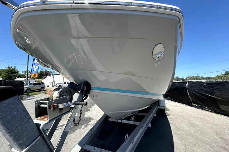 Slide: The Image of 2021 Regal 26 FasDeck boat on trailer, viewed from the front, under clear blue sky. - 12