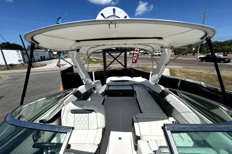 Slide: The Image of 2021 Regal 26 FasDeck boat interior with spacious seating and canopy under clear sky. - 24