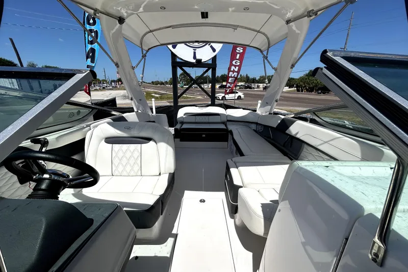 Slide: The Image of 2021 Regal 26 FasDeck boat interior with white seating and steering wheel. - 25