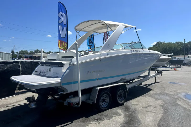 Slide: The Image of 2021 Regal 26 FasDeck boat on trailer, displayed outdoors under clear blue sky. - 3