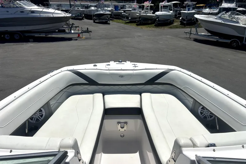 Slide: The Image of 2021 Regal 26 FasDeck boat interior with white seating, parked among other boats. - 30
