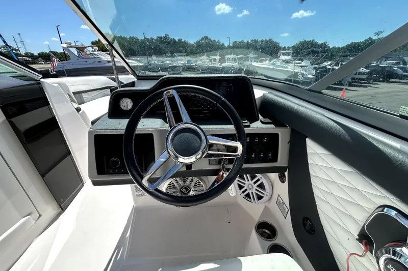 Slide: The Image of Cockpit view of 2021 Regal 26 FasDeck boat with steering wheel and dashboard controls. - 34