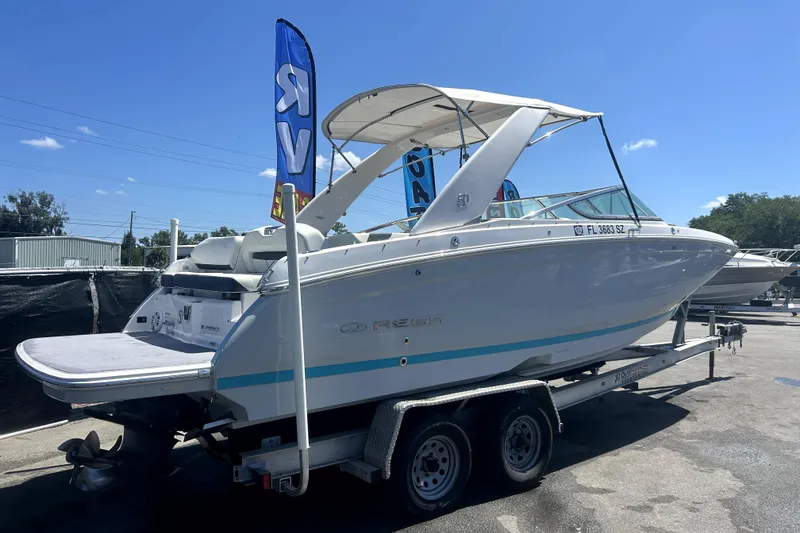 Slide: The Image of 2021 Regal 26 FasDeck boat on trailer under clear blue sky. - 4