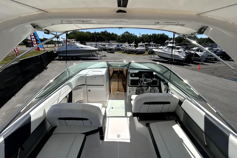 Slide: The Image of 2021 Regal 26 FasDeck boat interior with seating and steering wheel, docked at marina. - 40