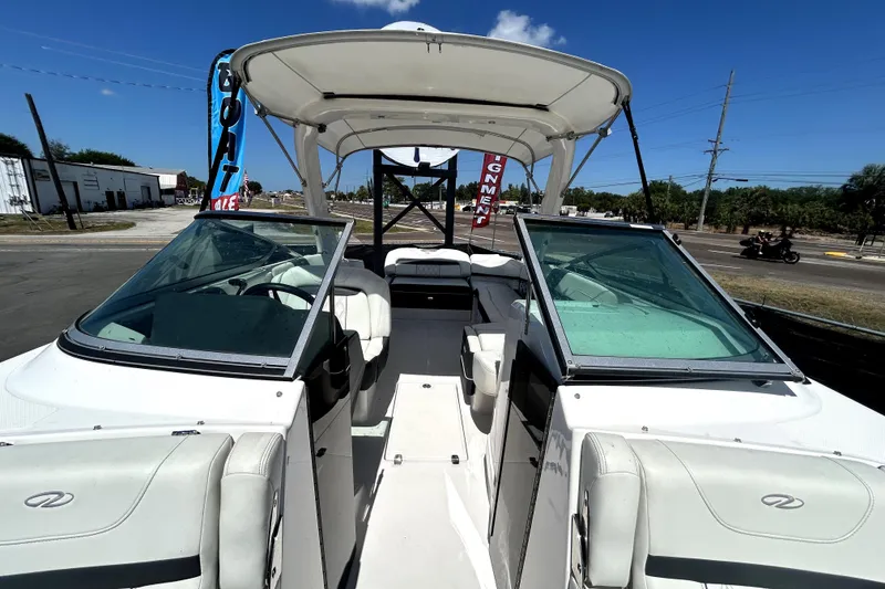 Slide: The Image of 2021 Regal 26 FasDeck boat with open cockpit and seating, displayed outdoors. - 51