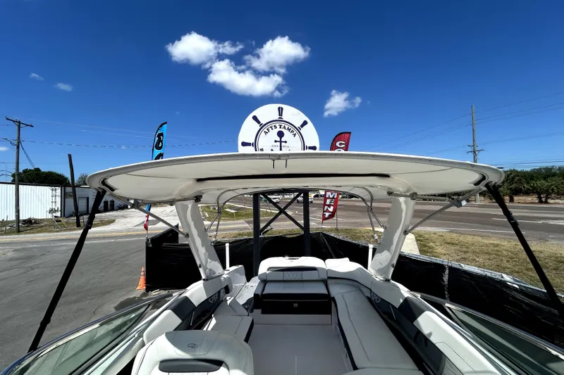Slide: The Image of 2021 Regal 26 FasDeck boat with canopy under clear blue sky. - 52