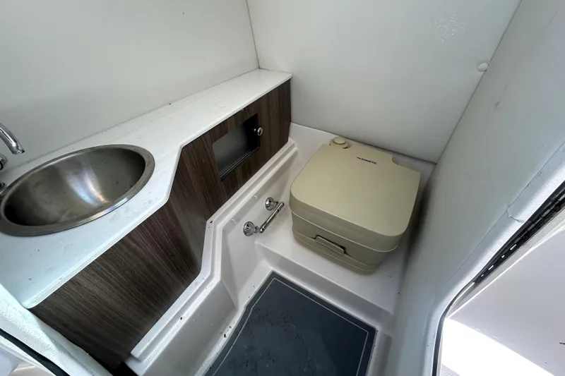 Slide: The Image of 2021 Regal 26 FasDeck boat bathroom with sink and portable toilet. - 58