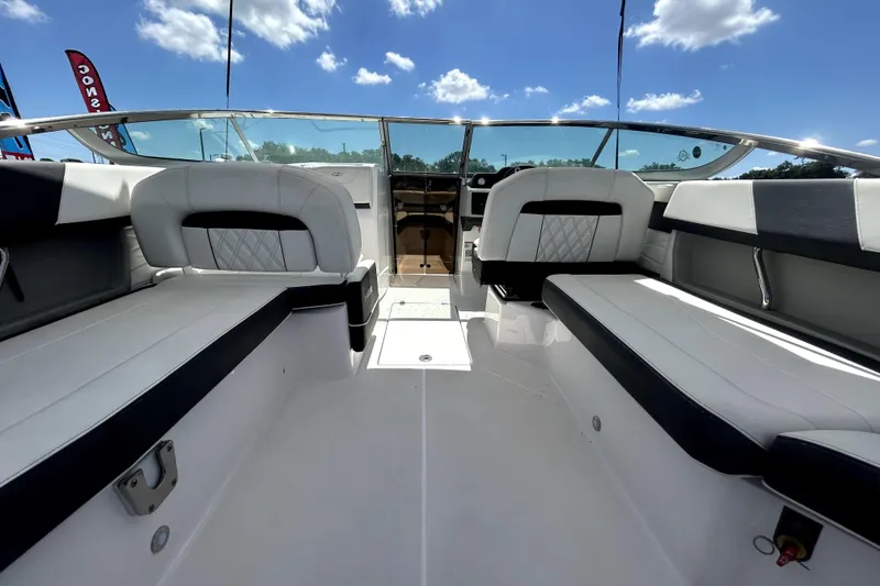 Slide: The Image of 2021 Regal 26 FasDeck boat interior with white seating and clear blue sky. - 60