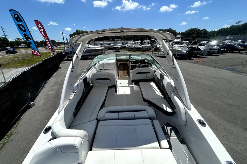 Slide: The Image of 2021 Regal 26 FasDeck boat with spacious seating, displayed outdoors under a clear sky. - 63