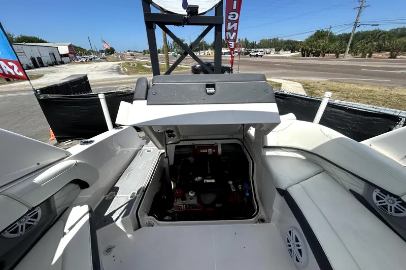 Slide: The Image of 2021 Regal 26 FasDeck boat interior with open engine compartment, showcasing seating and speakers. - 68