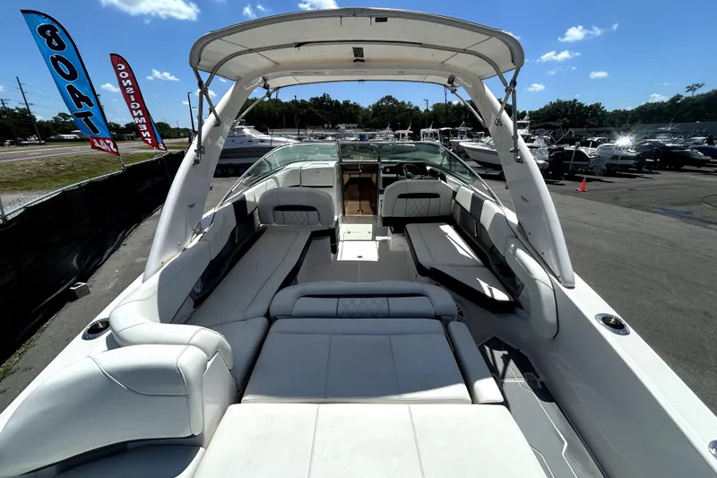 Slide: The Image of 2021 Regal 26 FasDeck boat with spacious seating and canopy, displayed at a dealership. - 72